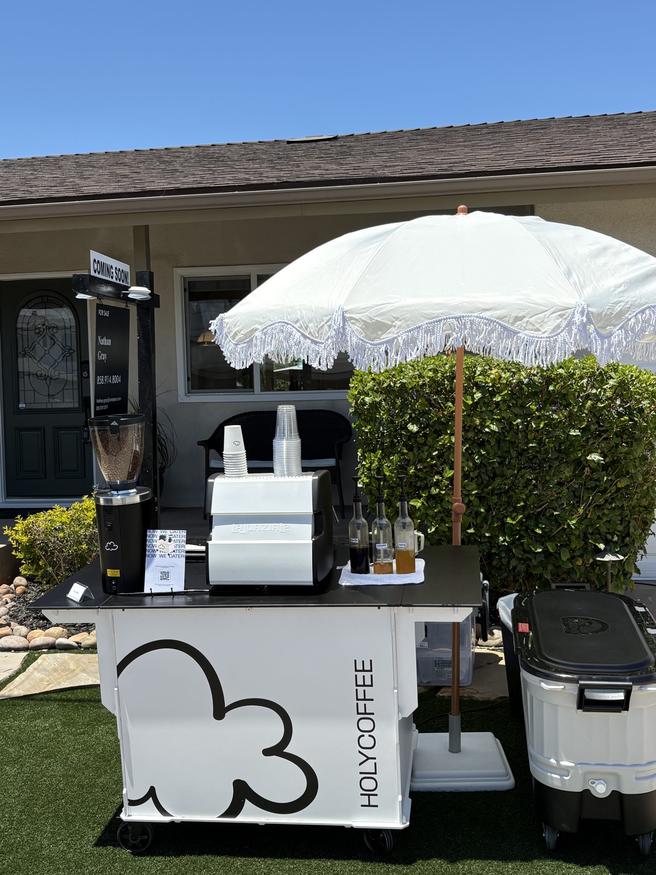 Holy Coffee cart with a white umbrella on a backyard lawn