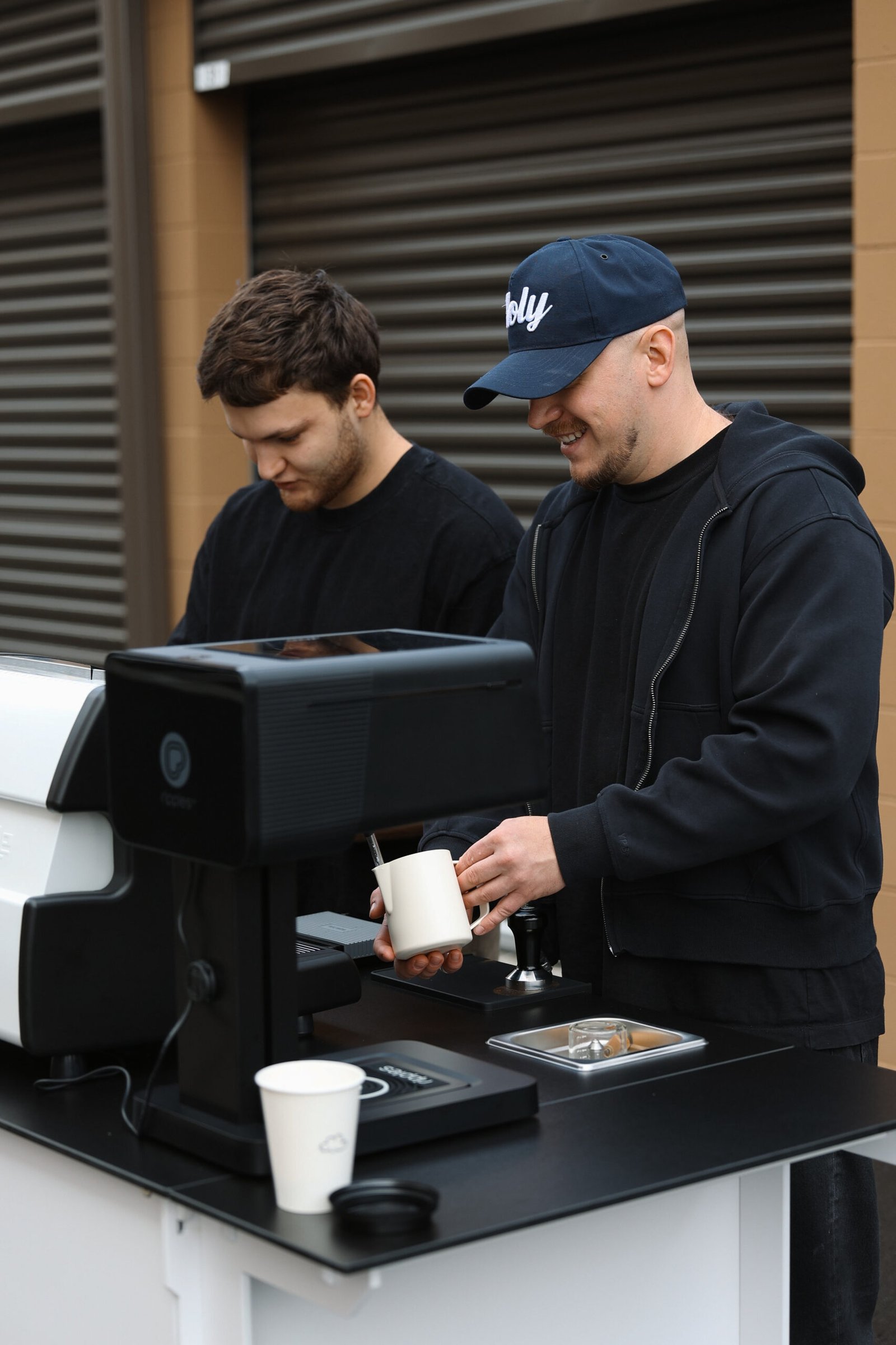 Two Holy Coffee baristas making drinks at the cart