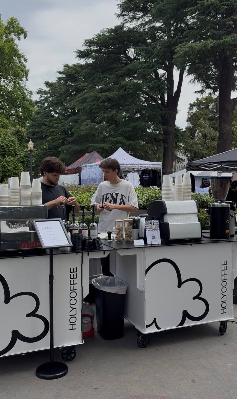 Two Holy Coffee carts serving side by side at an outdoor festival
