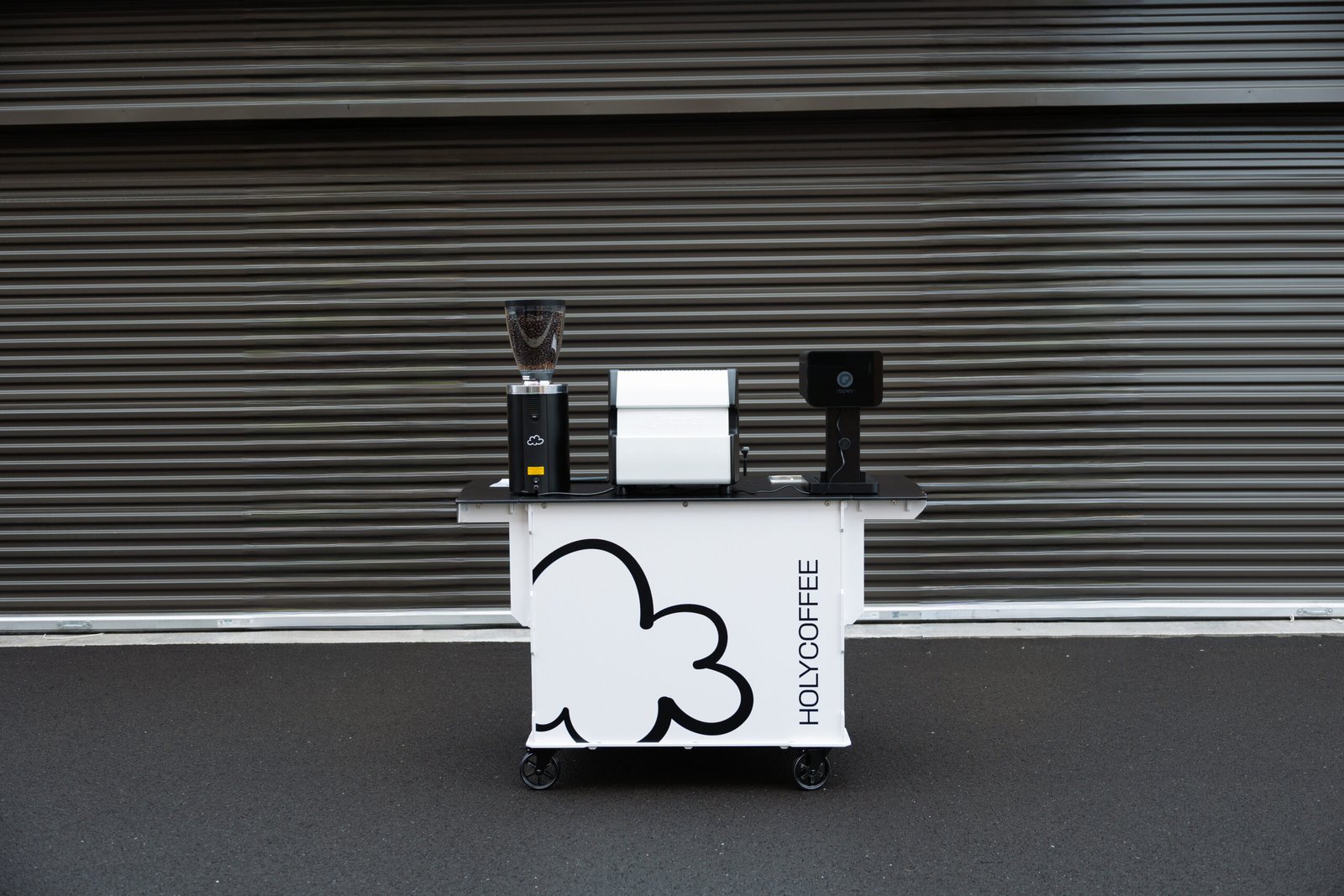 The white Holy Coffee cart set up with its equipment