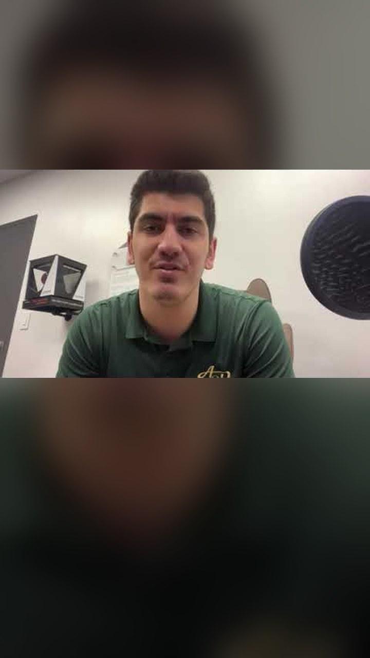 A client from Attn 2 Detail in a green polo talking on a video call
