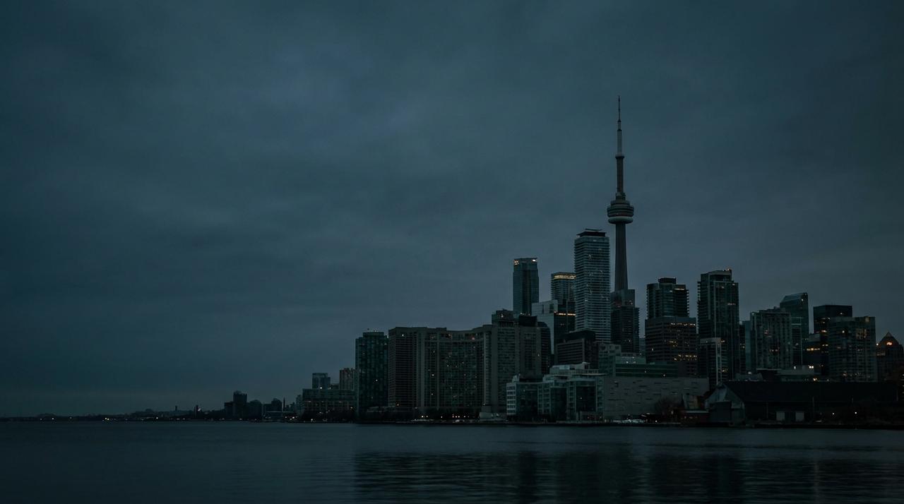 Toronto skyline at dusk with the CN Tower, seen across Lake Ontario