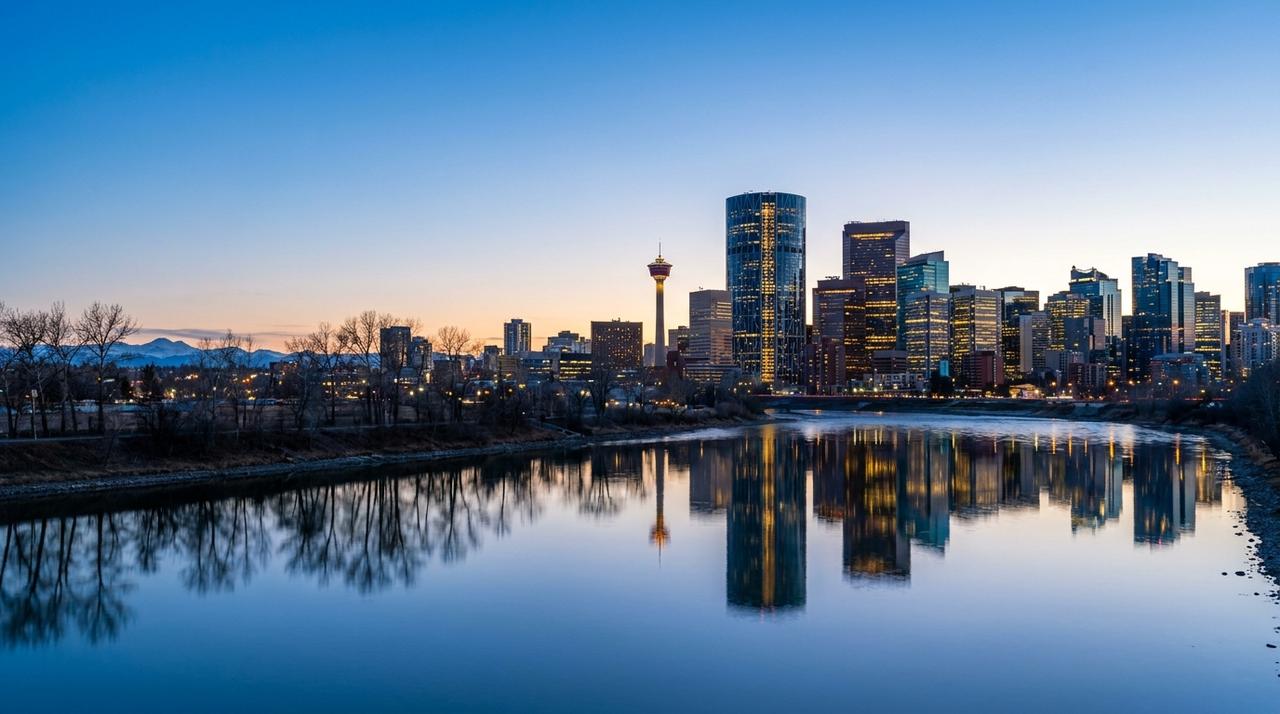Downtown Calgary skyline at blue hour across the Bow River, with the Calgary Tower