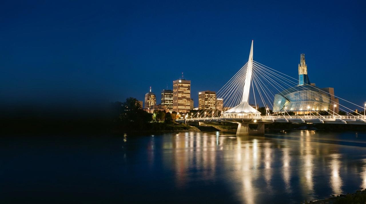 Downtown Winnipeg at blue hour from across the Red River at The Forks, with the Canadian Museum for Human Rights lit up