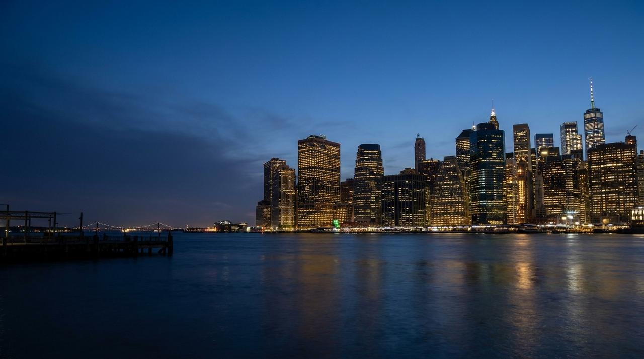 Lower Manhattan skyline at blue hour, seen across the East River from the Brooklyn waterfront