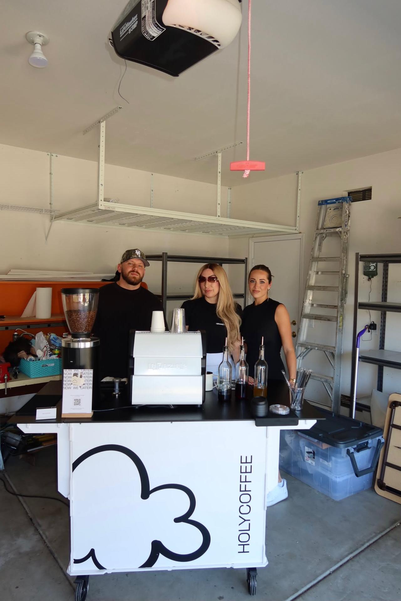 Holy Coffee team standing behind the white Holy Coffee cart