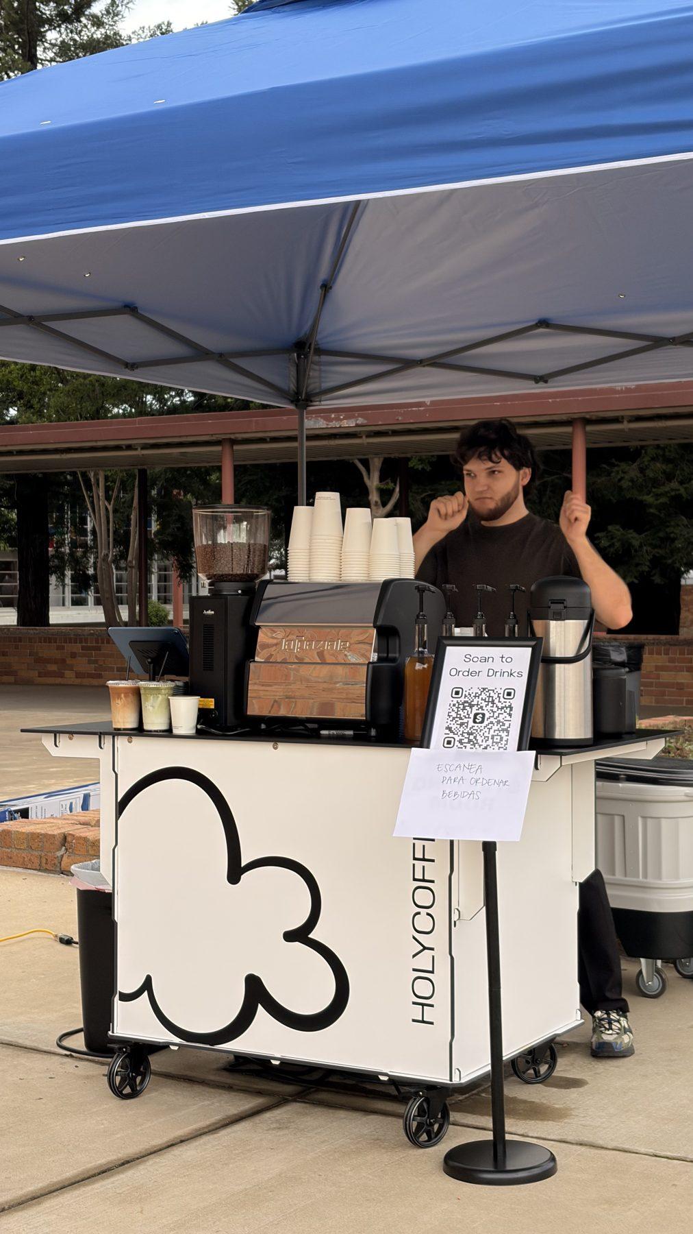 Holy Coffee cart under a blue canopy at an outdoor event