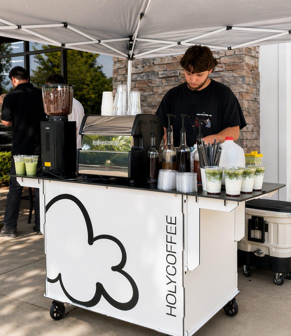 Barista pulling espresso at the Holy Coffee cart under a white event tent
